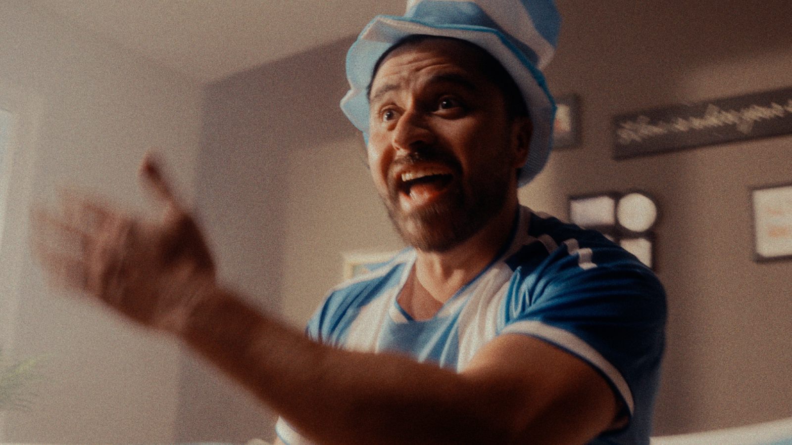 A fan celebrating in front of the TV