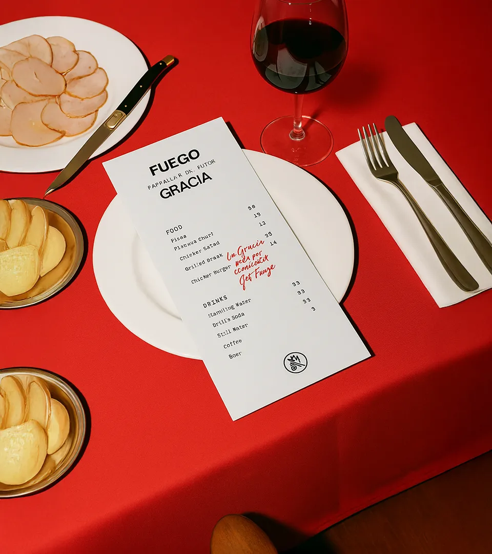 Mesa servida con mantel rojo y menú impreso