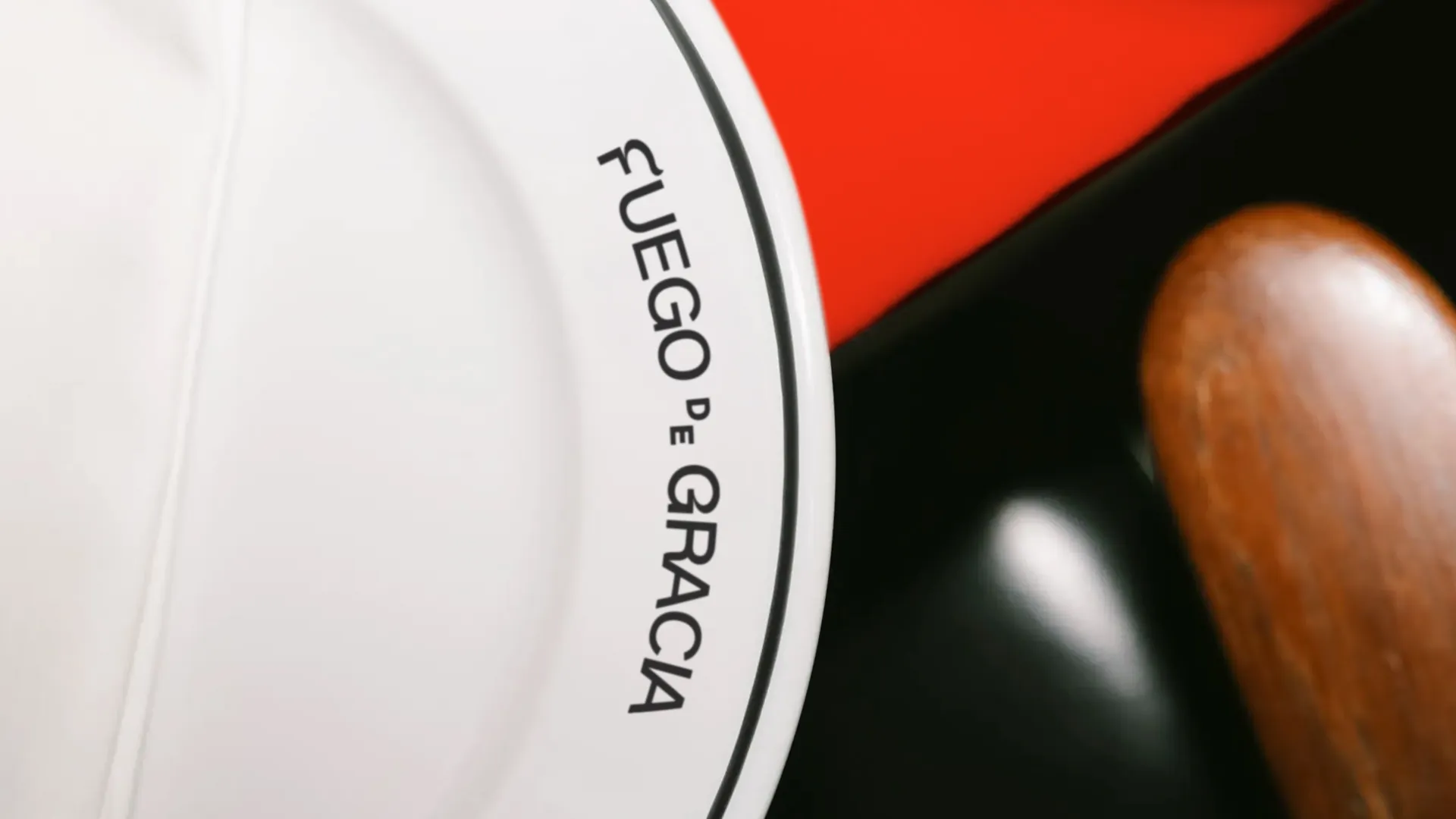 Plato blanco con el logotipo Fuego de Gracia sobre mantel rojo