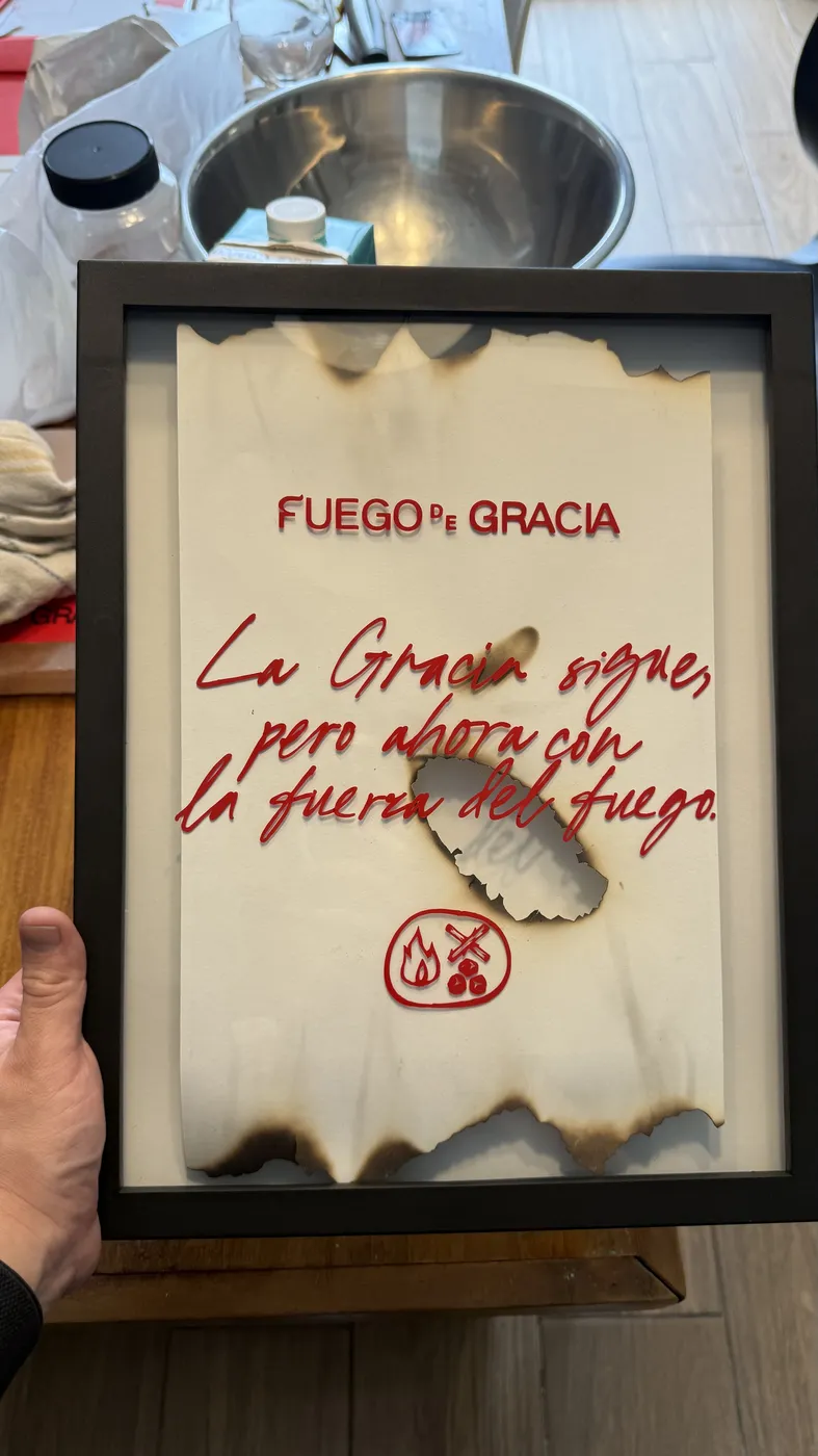 El manifiesto con bordes quemados, enmarcado y sostenido en la mano